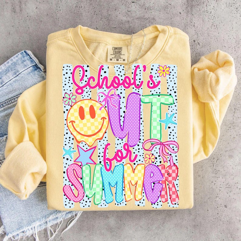Puede incluir: Sudadera amarilla clara con el texto "School's Out for Summer" en letras coloridas y divertidas. El dise&ntilde;o incluye una carita sonriente, estrellas y flores. La sudadera es de la marca Comfort Colors.