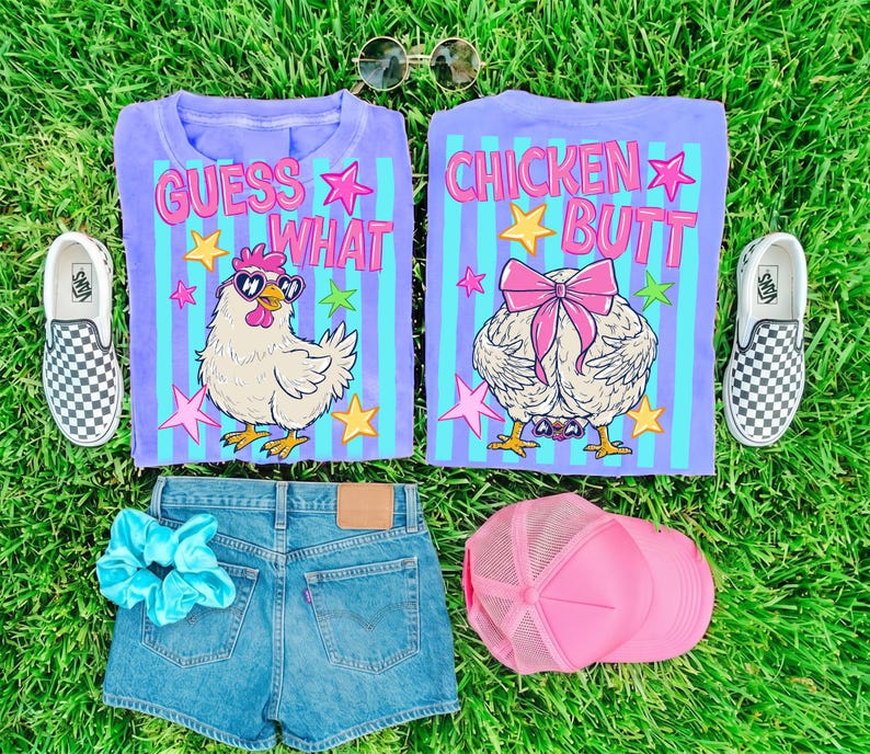 May include: A flat lay featuring a purple t-shirt with the text "GUESS WHAT" and a cartoon chicken wearing sunglasses, and another shirt with the text "CHICKEN BUTT". Also included are denim shorts, a pink trucker hat, a blue scrunchie, and checkered slip-on shoes.