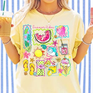 Puede incluir: Camiseta amarilla con un gr&aacute;fico colorido de tem&aacute;tica veraniega. El dise&ntilde;o incluye una rodaja de sand&iacute;a, un pulpo, un sol, una c&aacute;mara, un cono de helado y el texto "Summer Vibes". La camiseta tiene mangas cortas.