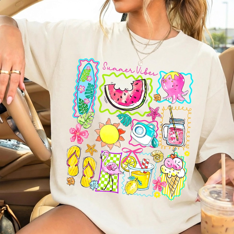 Puede incluir: Camiseta color crema con un gr&aacute;fico colorido de tem&aacute;tica veraniega. El dise&ntilde;o incluye una rodaja de sand&iacute;a, un pulpo, un sol, una c&aacute;mara y un cono de helado, con el texto "Summer Vibes". La camiseta tiene un corte holgado.