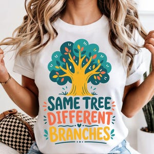 May include: White t-shirt with a vibrant tree design and the words "SAME TREE DIFFERENT BRANCHES". The tree has a yellow trunk, teal leaves, and orange and red accents. The text is in teal, orange, and yellow.