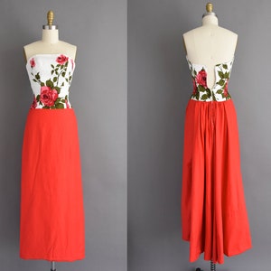 May include: A strapless red and white floral print dress with a fitted bodice and a full skirt. The dress is made of a lightweight fabric and has a zipper closure in the back.