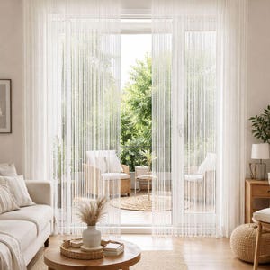 May include: A light and airy living room featuring sheer white curtains and a view of a patio. A round wooden coffee table sits on a woven rug, with a sofa and decorative vase adding to the cosy atmosphere.