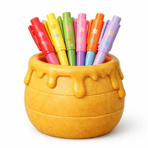 May include: A collection of colorful pens in a honey pot-shaped holder. The pens are red, yellow, green, pink, orange, and purple, each with a different design. The honey pot is a warm yellow color with dripping honey details.
