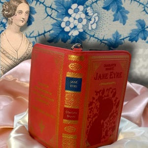 Jane Eyre book wallet opened like a book on ivory satin, displaying front and back covers with visible spine structure