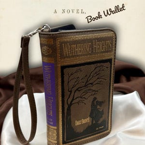 Spine detail of Wuthering Heights wallet shown upright on satin fabric, emphasizing the classic book style construction and gothic inspired design