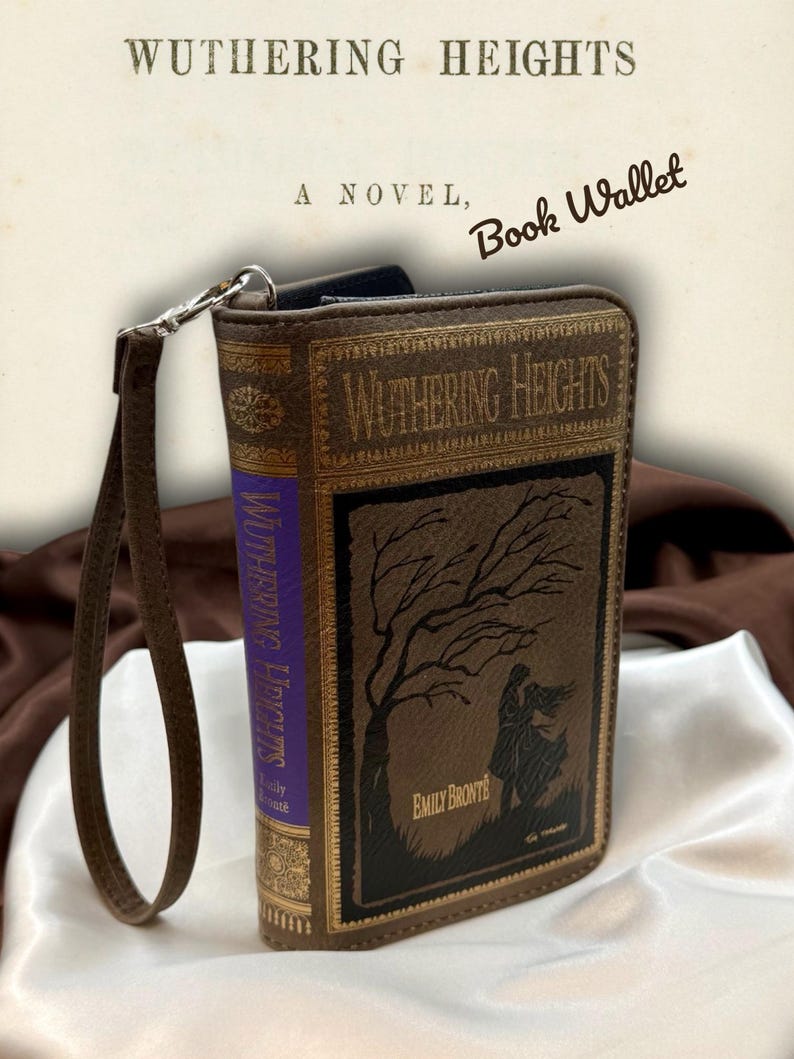 Spine detail of Wuthering Heights wallet shown upright on satin fabric, emphasizing the classic book style construction and gothic inspired design