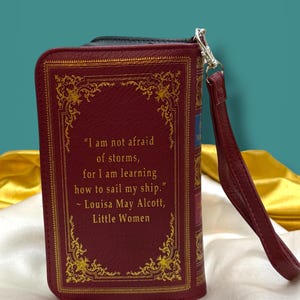 Little Women book wallet back cover shown with quote from the story, "I am not afraid of storms, for I am learning how to sail my ship."  and as a book-style clutch