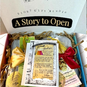 StoryGiftStudio order packaged in gift box with book wallets wrapped in organza bags, satin ribbon ties, and certificate of a StoryGiftStudio treasure placed on top