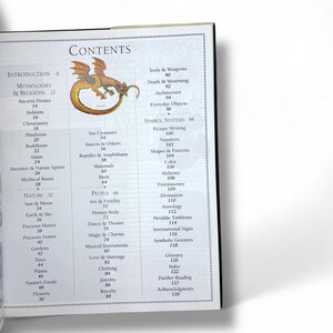 May include: A book titled "The Language of Symbols" with a table of contents listing various categories of symbols, including mythologies, religions, nature, people, and symbol systems. The book cover features an illustration of a green dragon.