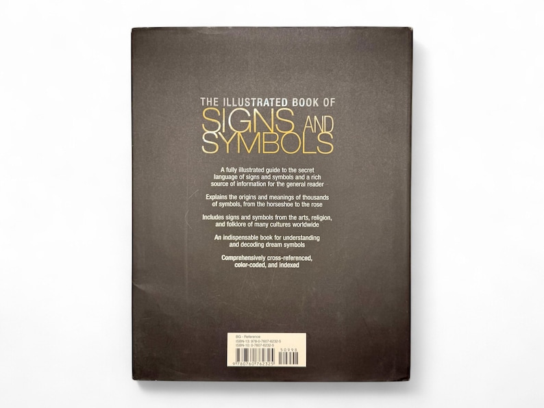 May include: The back cover of a book titled "The Illustrated Book of Signs and Symbols". The book cover is brown with gold lettering. The text on the back cover describes the book as a fully illustrated guide to the secret language of signs and symbols.