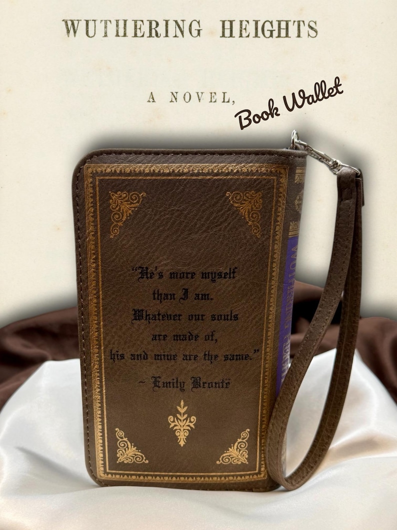 Back view of Wuthering Heights book wallet displayed on ivory satin, featuring the printed quote and attached wristlet strap