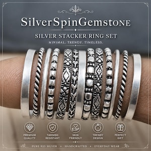 Könnte beinhalten: Ein Set aus silbernen Stapelringen mit verschiedenen Designs, darunter gedrehte Seil-, Perlen- und gemusterte Bänder. Die Ringe werden an einem Finger gezeigt. Der Text "Silver SpinGemstone" und "Silver Stacker Ring Set" ist sichtbar.