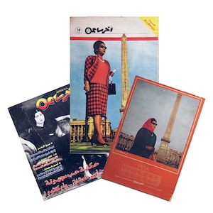 Pode incluir: Três revistas vintage com texto e imagens em árabe. As capas apresentam ilustrações de mulheres, uma com uma roupa vermelha com saia xadrez, outra em uma foto em preto e branco e uma terceira com uma mulher com um lenço vermelho.