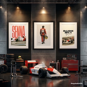 May include: Three framed posters featuring Ayrton Senna and the McLaren MP4/4 race car displayed above a full-scale Formula 1 race car in a garage. The posters include text reading SENNA and MCLAREN MP4/4 with a signature and racing imagery.