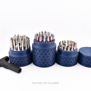 May include: A set of dark blue bit holders with a honeycomb pattern, filled with various silver bits. A black T-handle tool is on the left. The text "hex bits not included" is at the bottom.