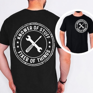 May include: A black t-shirt featuring a large white circular graphic on the back and a smaller version on the front left chest. The design includes a crossed wrench and screwdriver with the text "KNOWER OF STUFF" and "FIXER OF THINGS".