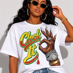 Puede incluir: Una camiseta blanca con un estampado gráfico de una mano haciendo un gesto de ok, adornada con varias pulseras con incrustaciones de diamantes y un reloj. El texto Clock It está impreso en una fuente estilizada de color verde, amarillo y rojo.