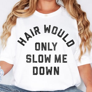 Peut inclure: Un t-shirt blanc à manches courtes avec le texte noir "HAIR WOULD ONLY SLOW ME DOWN" imprimé en caractères gras et pointillés sur la poitrine. Le t-shirt présente une encolure ronde, une coupe décontractée et est porté avec un jean bleu.