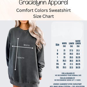 May include: Size chart for a Comfort Colors sweatshirt from Gracielynn Apparel. The chart shows measurements for width, length, and sleeve length in inches for sizes S to 3XL. The sweatshirt is shown in a dark gray color. The text also mentions the fabric composition.