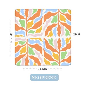 May include: Square neoprene mat with a colorful abstract floral design. The mat is 31.5 inches square and 2mm thick. The design features orange, yellow, green, pink, and blue shapes on a white background. The word "NEOPRENE" is printed on the bottom.
