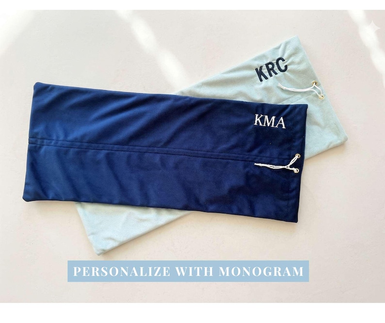 May include: Two rectangular fabric pouches with drawstring closures. One pouch is dark navy blue with the white embroidered monogram KMA, and the other is light sage green with the black embroidered monogram KRC. Text reads PERSONALIZE WITH MONOGRAM.