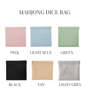May include: A collection of six square Mahjong dice bags in various colors: pink, light blue, green, black, tan, and light grey. Each bag is labeled with its respective color name.