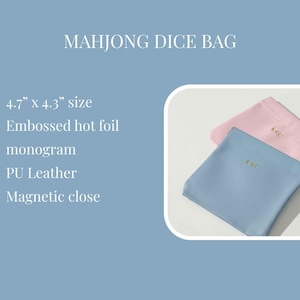 May include: Two small PU leather Mahjong dice bags, one light blue and one pink, each with a gold embossed monogram. The bags are approximately 4.7" x 4.3" in size and have a magnetic closure.