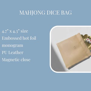 May include: A beige PU leather Mahjong dice bag with a magnetic closure, embossed monogram, and a gold-colored flower-shaped dice holder. The bag measures 4.7" x 4.3". Two dice are visible in the holder.