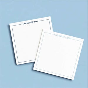 May include: Two white square notepads with blue borders and text. One notepad reads "MOLLY JOHNSON" and the other reads "KATHERINE SMITH". The notepads are on a light blue background.