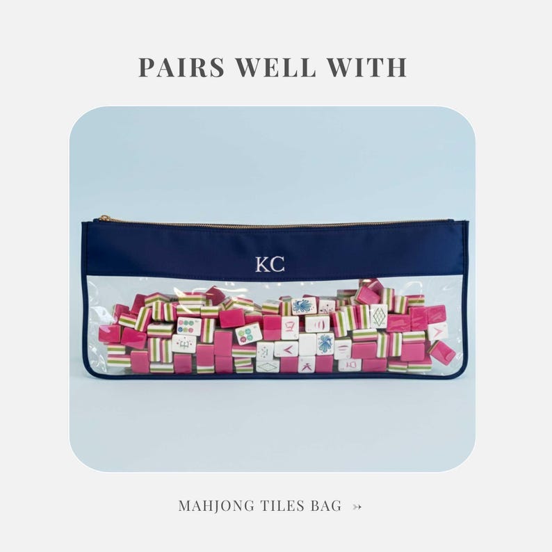 May include: A navy blue Mahjong tiles bag with a clear front, gold zip, and the initials "KC". The bag is filled with pink, white, and green Mahjong tiles. Text at the top reads "PAIRS WELL WITH" and at the bottom "MAHJONG TILES BAG".