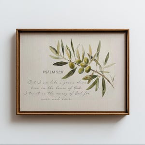 Può includere: Stampa incorniciata con un'illustrazione ad acquerello di un ramo d'ulivo con olive verdi. Il testo "PSALM 52:8" e un versetto biblico sono stampati sotto. La cornice è di colore marrone caldo.