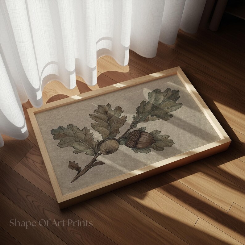 May include: A framed print featuring a detailed illustration of oak leaves and acorns in shades of green and brown. The artwork is set against a neutral background and framed in a light wood. The text "Shape Of Art Prints" is visible at the bottom.