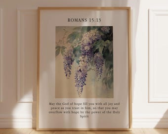 Puede incluir: Una impresión enmarcada con una pintura de acuarela de flores de glicinia moradas colgando de una rama. La impresión tiene el texto "Romanos 15:13" y una cita sobre la esperanza, la alegría y la paz.