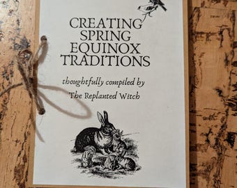 Pode incluir: Um cartão creme com o texto "CREATING SPRING EQUINOX TRADITIONS" e uma ilustração de um coelho. O cartão é amarrado com barbante e inclui o texto "thoughtfully compiled by The Replanted Witch."