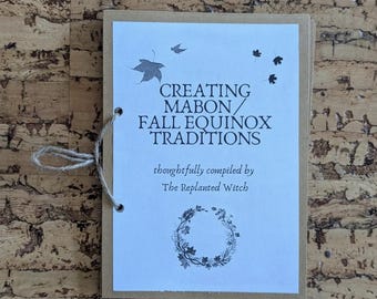 Pode incluir: Um pequeno livreto com capa de papel kraft e páginas internas brancas. A capa apresenta o texto "CREATING MABON / FALL EQUINOX TRADITIONS" com ilustrações de folhas. O livreto é encadernado com um barbante.