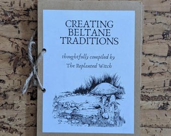 Pode incluir: Um pequeno livreto encadernado com uma capa branca com o texto "CREATING BELTANE TRADITIONS" e uma ilustração de um cogumelo e figuras. O livreto é encadernado com barbante e tem uma capa castanha.