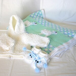 May include: A white crocheted baby outfit with a hood, booties, and a green and white crocheted blanket with a blue and white checkered pattern.