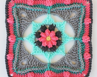 May include: A square crochet motif featuring a central yellow, pink, and dark gray flower. The design radiates outward with layers of turquoise, gray, and pink yarn, incorporating textured bobble stitches and openwork corners.