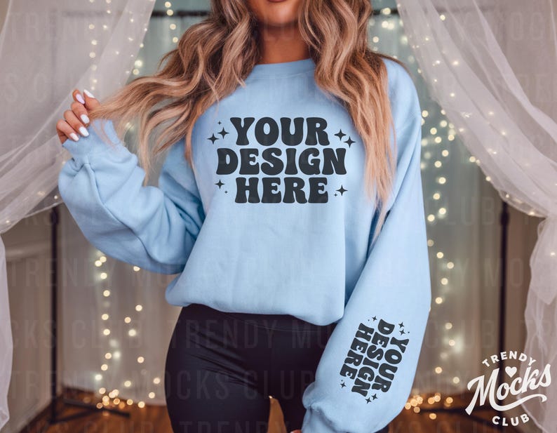 May include: A light blue sweatshirt with the text "YOUR DESIGN HERE" in black on the front and the text "YOUR DESIGN HERE" in black on the sleeve.