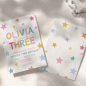 Puede incluir: Dos invitaciones de cumpleaños blancas con patrones de estrellas coloridas. Una invitación dice "OLIVIA is turning THREE" con detalles del evento. La otra invitación presenta un diseño de estrellas dispersas. Las invitaciones son para el tercer cumpleaños de Olivia.