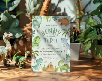May include: A green and white dinosaur-themed birthday party invitation for Henry's third birthday. The invitation features a watercolor illustration of dinosaurs, leaves, and a volcano. The text on the invitation reads "Stomp on over Henry is turning three. Please join us to celebrate Saturday May 17 at 2pm to Raptor Ridge, Dino Valley. RSVP Kate 041 234 567."