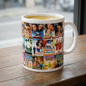 May include: A white ceramic mug filled with a warm beverage. The mug is covered in a collage of colorful movie posters. The mug has a white handle and sits on a wooden surface.