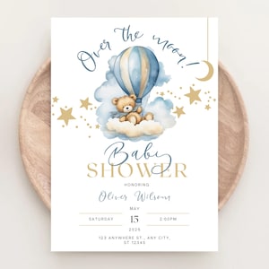 Può includere: Un invito a una festa di benvenuto per un bambino con uno schema di colori blu e oro. L'invito presenta un orsacchiotto in un pallone aerostatico che vola sopra una nuvola con le stelle. Il testo sull'invito recita "Over the moon!" e "Baby Shower" con il nome "Oliver Wilson" e la data e l'ora della festa.