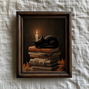 Peut inclure: Peinture encadrée d'un chat noir endormi sur une pile de livres. Une bougie allumée diffuse une lueur chaleureuse. L'œuvre a une esthétique sombre et mélancolique, avec des feuilles d'automne. Le cadre est marron foncé.