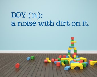 May include: A colorful wooden block tower with a blue, green, yellow, and red color scheme. The blocks are stacked in a tower with an archway at the top. The blocks are scattered on a wooden floor. The text "BOY (n): a noise with dirt on it." is written on a blue wall.