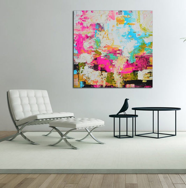May include: A square abstract painting featuring thick, textured impasto brushstrokes in vibrant shades of hot pink, bright turquoise, sunny yellow, and white, contrasted with deep black accents across the entire canvas surface.