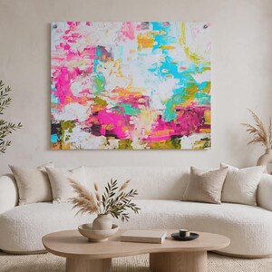 May include: A large rectangular wall art piece featuring an abstract composition with vibrant splashes of hot pink, bright turquoise, sunny yellow, and white paint. The artwork displays thick, textured brushstrokes and layered color blocks.