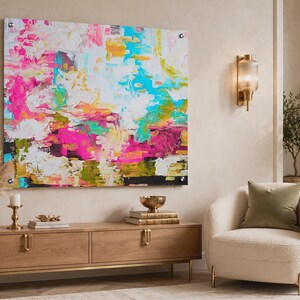 May include: A large rectangular wall art piece featuring an abstract composition with vibrant splashes of hot pink, bright turquoise, sunny yellow, and white paint. The artwork is mounted with four silver metal standoffs at each corner.