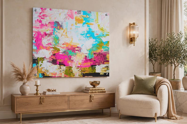 May include: A large rectangular wall art piece featuring an abstract composition with vibrant splashes of hot pink, bright turquoise, sunny yellow, and white paint. The artwork is mounted with four silver metal standoffs at each corner.
